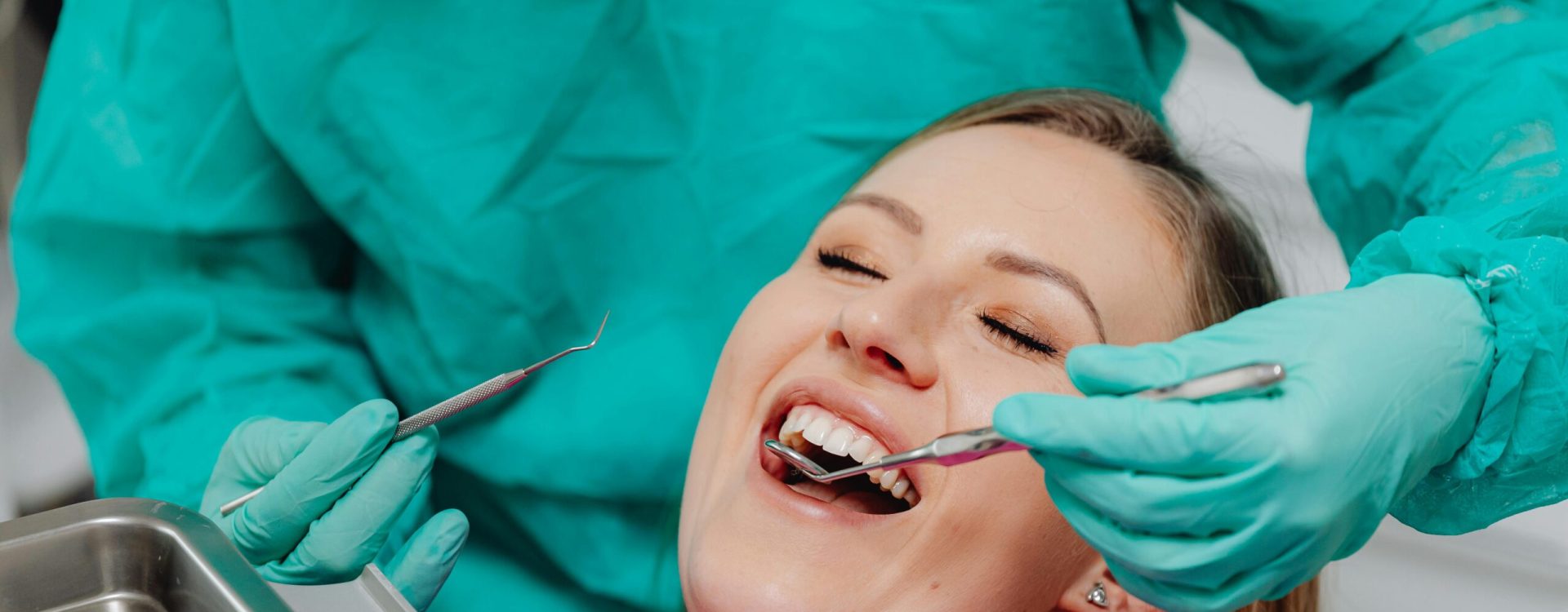 A happy woman receiving a dental examination, showing confidence in professional oral care.